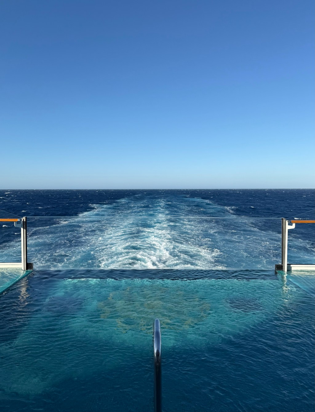 Cruise ship sailing at sea on embarkation day, viewed from the pool deck